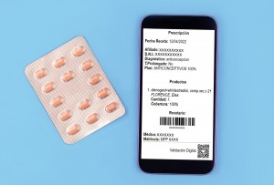 Pill blister and smartphone on blue background.